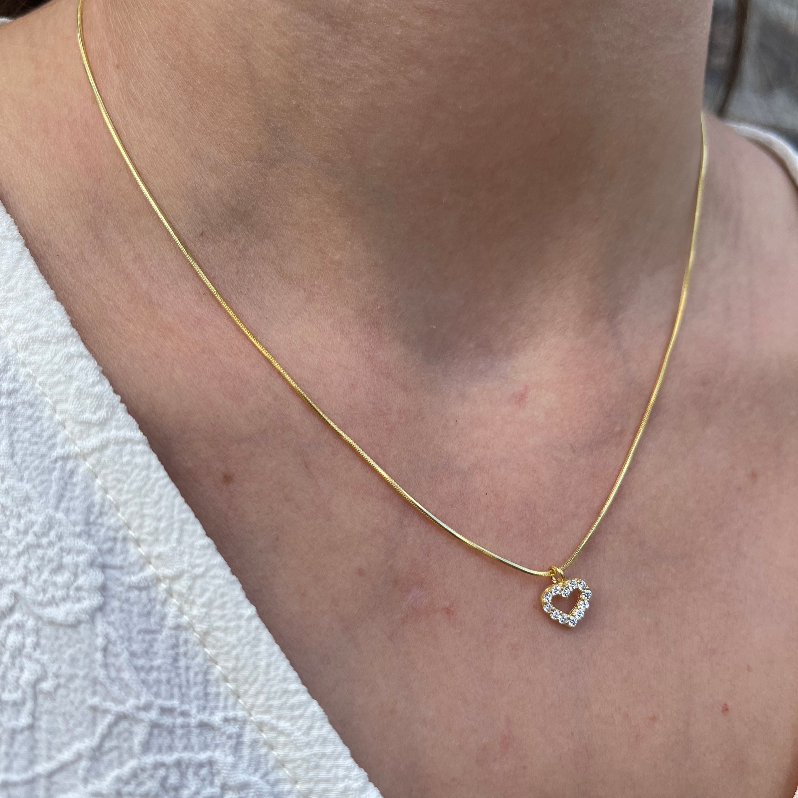 Gouden ketting met hart hanger bezet met zirconia, gemaakt van 925 sterling zilver, gedragen om de hals