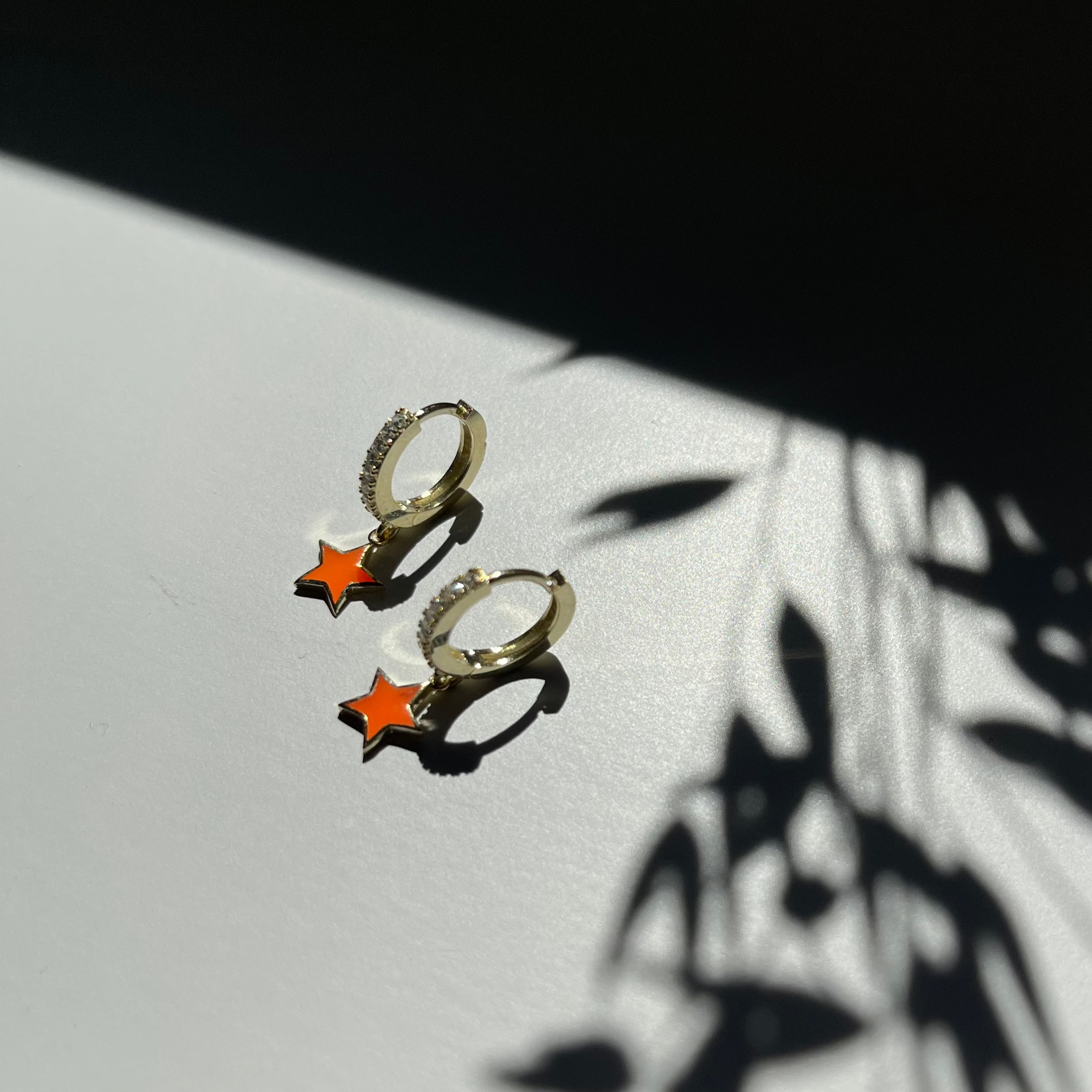 Kinderoorbellen met oranje sterhanger aan een goudkleurige ring